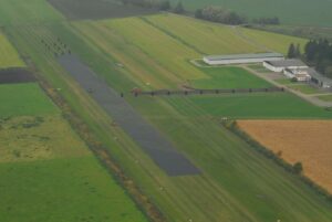Fast installation of grass reinforcement grids TERRA-GRID E 35 for runway stabilization