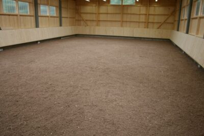 Ground reinforcement with paddock grids in indoor riding arenas
